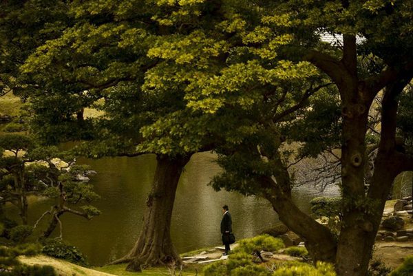 Một người đàn ông đứng trước bờ hồ ở công viên Kyu-Shiba-rikyu Garden trong thời tiết nắng ấm ở Tokyo ngày 18-3